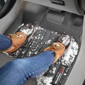 Tappetino WeatherTech Custom Fit per la prima fila, nero, con immagine di neve e di una persona con stivali e jeans