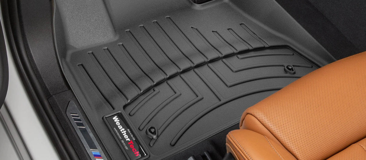 Black car floor mat with WeatherTech logo on a vehicle interior.