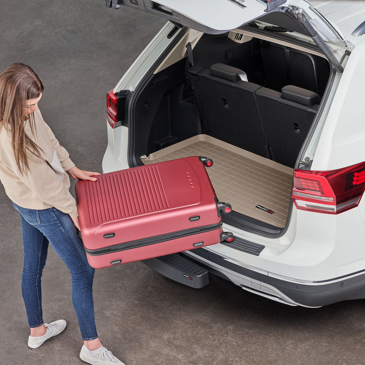 Bumper protector on VW Atlas protecting rear bumper by weathertech with woman loading suitcase.