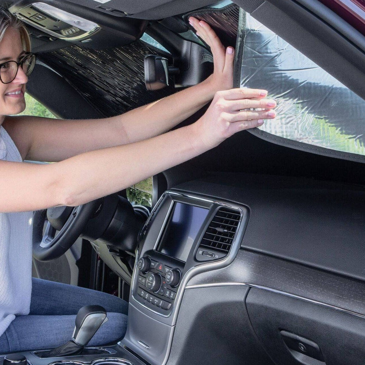 Installing WeatherTech Sunshade, by ensuring the material covers edging is pushed firmly into the front car window frame for that 100% perfect fit